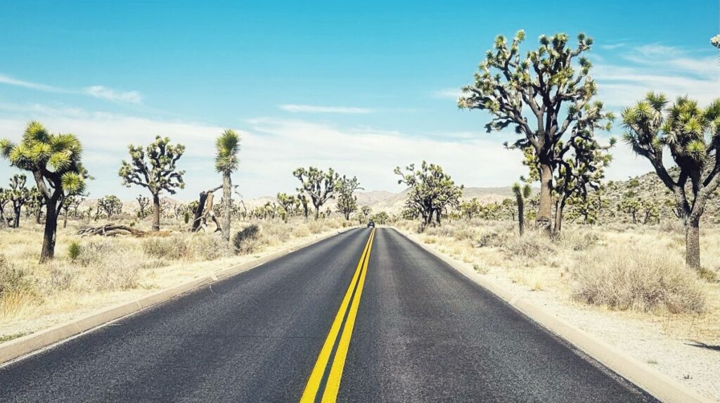 Open highway stretching through the American desert, symbolizing full-time nomadic travel, personal growth, and the journey toward intentional living.